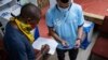 An electoral commission official prepares to seals ballot boxes at the Fordsburg Primary School polling station under the supervision of party delegates during local elections, in Johannesburg, South Africa, Nov. 1, 2021.