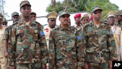 Somali President Mohamed Abdullahi Mohamed, center, Somalia Prime Minister Hassan Ali Khayre, right , and Defense Minister Abdirashid Abdulahi Mohamed watch a military unit during celebrations marking the 57th anniversary since Somali military was founded, in Mogadishu, Somalia, April 12, 2017.