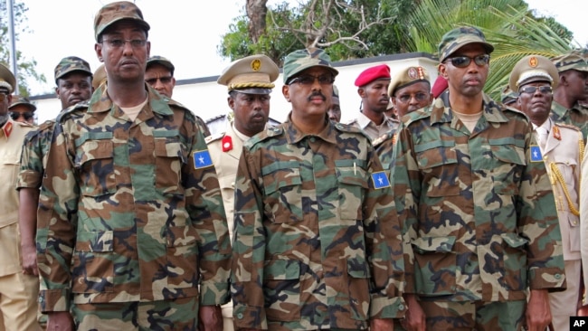 Somali President Mohamed Abdullahi Mohamed, center, Somalia Prime Minister Hassan Ali Khayre, right , and Defense Minister Abdirashid Abdulahi Mohamed watch a military unit during celebrations marking the 57th anniversary since Somali military was founded, in Mogadishu, Somalia, April 12, 2017.