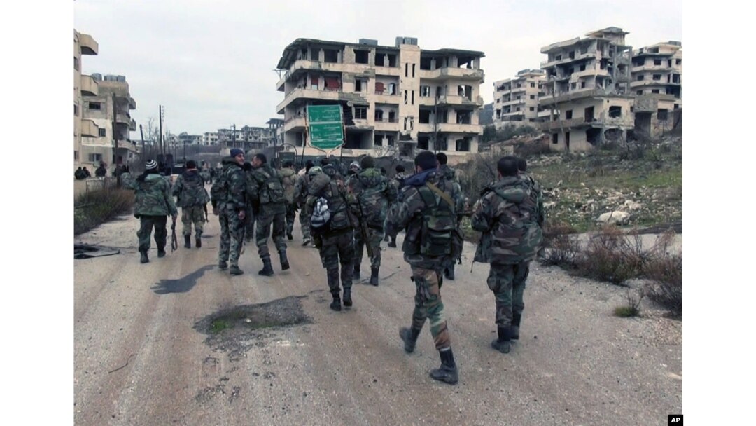 FILE - Syrian government troops and allied militiamen walk inside the key town of Salma in Latakia province, Syria, Jan 12, 2016.