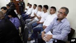 FILE - Men accused in the killing prize-winning Honduran indigenous and environmental rights activist Berta Caceres sit in a court room in Tegucigalpa, Honduras, Sept. 17, 2018.