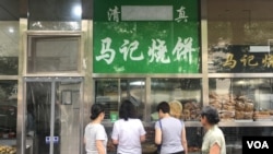 Aksara Arab pada papan nama di sebuah toko makanan halal di kawasan Niujie, Beijing, tampak ditutupi kain, 19 Juli 2019. (Foto: Reuters) 