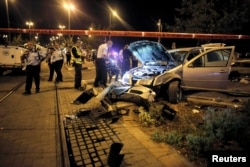 Israeli policemen inspect a car wreck in Jerusalem, Oct. 22, 2014.