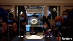 Visitors look at Moon samples from China's lunar exploration program Chang'e-5 Mission during an exhibition at the National Museum in Beijing, China March 3, 2021. (REUTERS/Tingshu Wang)