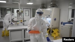 塞尔维亚贝尔格莱德的火眼病原分子检测国家实验室的科学家在检验新冠病毒的测试样本。（2020年5月12日）