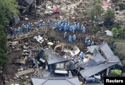 Rescue workers conduct a search and rescue operation to a collapsed house at a landslide site caused by earthquakes in Minamiaso town, Kumamoto prefecture, southern Japan, in this photo taken by Kyodo, April 16, 2016.