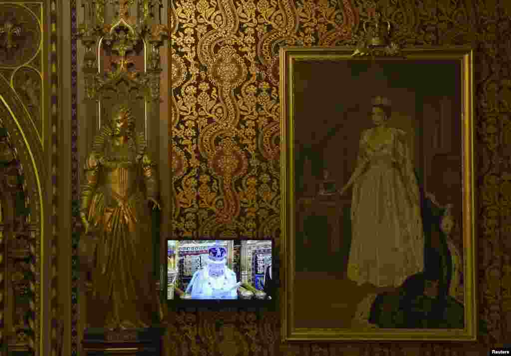 Britain&#39;s Queen Elizabeth is seen on a TV monitor as she delivers her speech during the opening of Parliament in the House of Lords, at the Palace of Westminster in London.