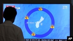一名男子在韩国首尔火车站观看朝鲜攻击美国关岛的新闻(2017年8月10日)