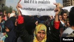 A Palestinian, who had fled the fighting in Syria, carries a sign during a protest in front of the Offices of the UNHCR in Beirut, Lebanon, Dec. 4, 2014.