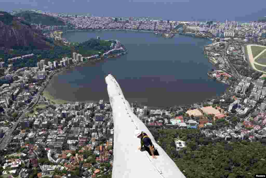 A worker inspects the Christ the Redeemer statue which was damaged during lightning storms in Rio de Janeiro, Brazil. Lightning strikes on Jan. 17, 2014, damaged the iconic figure&#39;s head and its right hand when a powerful electric storm swept through the city emitting more than 40,000 lightning strikes throughout the state of Rio de Janeiro.