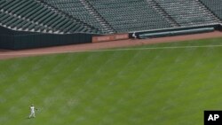 El jugador de los Medias Blancas de Chicago, Delmon Young, lanza la pelota en el partido sin público que juega su equipo contra los Orioles.