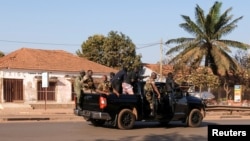 Armed soldiers move on the main artery of the capital after heavy gunfire around the presidential palace in Bissau, Guinea-Bissau, Feb. 1, 2022. 