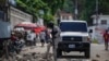 Polisi tampak membereskan susunan batu yang digunakan untuk memblokade jalan seusai protes yang dilakukan para warga di Port-au-Prince yang menyuarakan lemahnya sistem keamanan di Haiti pada 18 Oktober 2021. (Foto: AP/Joseph Odelyn)