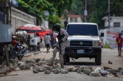 Police remove a roadblock set by protesters in Port-au-Prince, Haiti, Oct. 18, 2021.