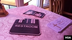 A broken restroom sign in the foyer at Wedgewood Church in Charlotte, North Carolina. (W. Gallo/VOA)