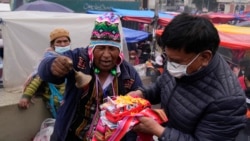 Un guía espiritual aymara bendice un auto en miniatura en la Feria anual de Alasita en La Paz, Bolivia, el lunes 24 de enero de 2022. (AP Foto/Juan Karita)