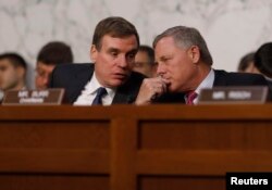 Senate Intelligence Committee ranking member Mark Warner (D-VA) (L) talks with Chairman Richard Burr (R-NC) during former FBI Director James Comey's appearance before a Senate Intelligence Committee hearing on Russia's alleged interference in the 2016 U.S. presidential election on Capitol Hill.