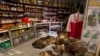 FILE — A North Korean woman stands behind the counter at a souvenir shop in Rajin, North Korea, inside the Rason Special Economic Zone. North Korea's Kim Jong Un has been busy recently building major tourist facilities.