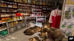FILE - A North Korean woman stands behind the counter at a souvenir shop in Rajin, North Korea, inside the Rason Special Economic Zone. North Korea recently laid out new laws to facilitate foreign tourism and investment.