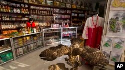 FILE — A North Korean woman stands behind the counter at a souvenir shop in Rajin, North Korea, inside the Rason Special Economic Zone. North Korea's Kim Jong Un has been busy recently building major tourist facilities.