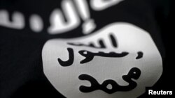 FILE- An Islamic State flag is seen in this photo illustration.