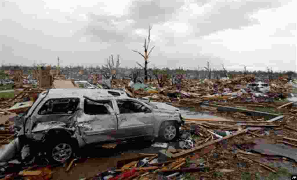 A car sits among rubble from a tornado Monday, May 23, 2011, in Joplin , Mo. A large tornado moved through much of the city Sunday, damaging a hospital and hundreds of homes and businesses. (AP Photo/Jeff Roberson)