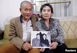 Former Vietnamese chemical student Pham Ngoc Canh who studied in North Korea and his North Korean wife Ri Yong Hui hold their first photo together which was taken in Spring 1971, at their house in Hanoi, Vietnam February 12, 2019. (REUTERS/Kham)