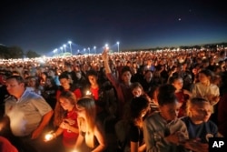 People hold up candles during a vigil for the victims of Wednesday's shooting at Marjory Stoneman Douglas High School, in Parkland, Florida, Feb. 15, 2018.