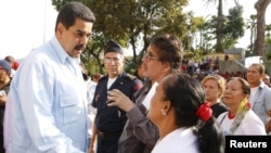 Venezuela's President Nicolas Maduro (L) talks with supporters during a mass at Miraflores Palace in Caracas, in this handout picture provided by Miraflores Palace, April 11, 2016. 