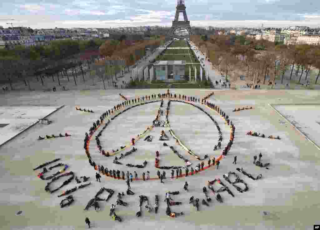 Environmentalist activists form a human chain representing the peace sign and the spelling out &quot;100% renewable&quot;, on the side line of the COP21, United Nations Climate Change Conference near the Eiffel Tower in Paris, France.