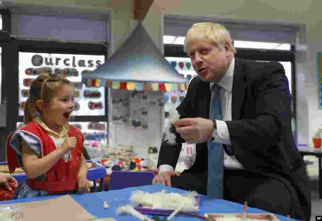 Britain&#39;s Prime Minister Boris Johnson gestures as he participates in an art class with Scarlet Fickling, 4, at St Mary&#39;s and All Saints Primary School in Beaconsfield, England.