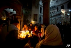 Christian pilgrims light candles during the Easter Sunday procession at the Church of the Holy Sepulchre, traditionally believed by many Christians to be the site of the crucifixion and burial of Jesus Christ, in Jerusalem, April 16, 2017.