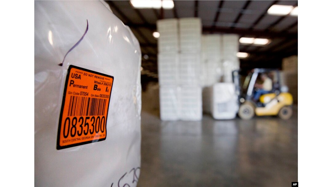 FILE - A bale of cotton sits packed and labeled while waiting to be shipped from the South Central Georgia Gin Company in Enigma, Ga., June 21, 2018. The company estimates that 40 to 50 percent of the cotton processed at the gin is exported out of the country, China being one of the main recipients.