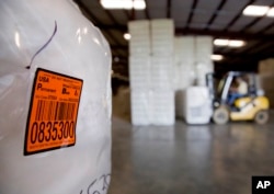 FILE - A bale of cotton sits packed and labeled while waiting to be shipped from the South Central Georgia Gin Company in Enigma, Ga., June 21, 2018. The company estimates that 40 to 50 percent of the cotton processed at the gin is exported out of the country, China being one of the main recipients.