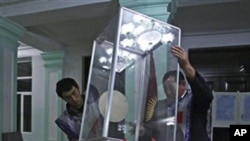 Members of local electoral committee empty a ballot box at a polling station in Osh, southern Kyrgyzsta, Sunday, 10 Oct. 2010.