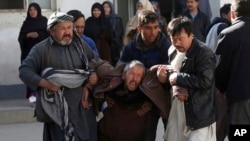 A distraught man is carried away following a suicide attack in Kabul, Afghanistan, Dec. 28, 2017. Authorities say attackers stormed the Shiite Muslim cultural center in the Afghan capital Kabul, setting off multiple bombs and killing dozens.