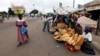 Street vendors sell loaves of bread and other wares on a street in Bouake, Ivory Coast, December 2010.