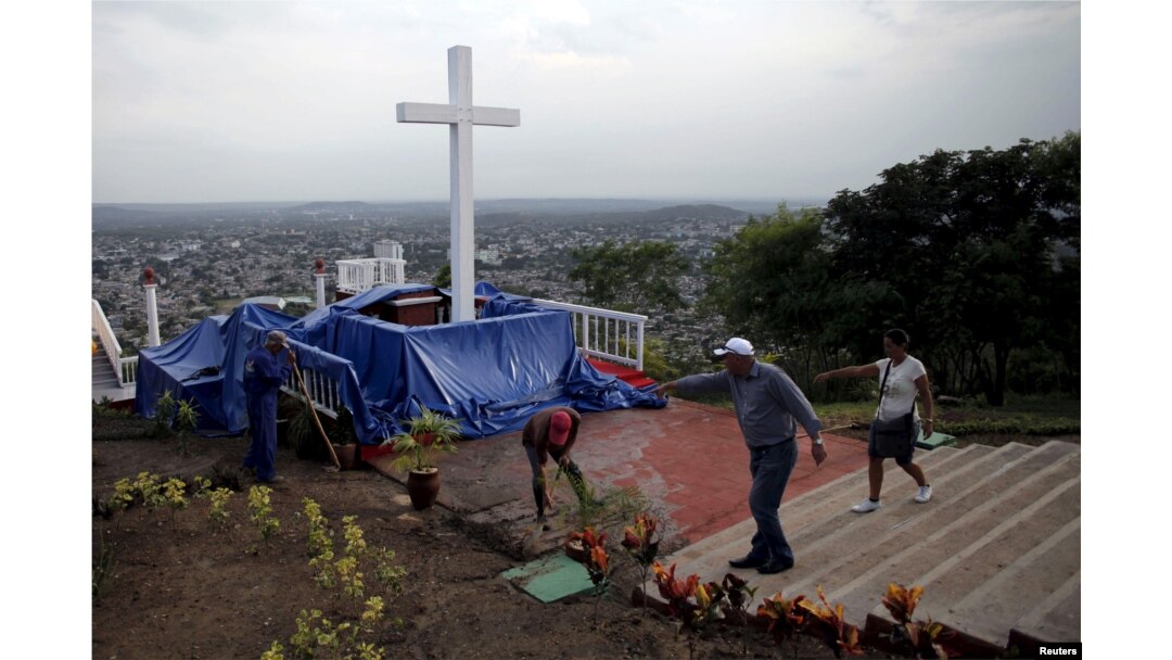 Para pekerja membersihkan Loma de la Cruz, sehari sebelum kunjungan Paus Fransiskus ke Holguin di Kuba, 20 September 2015.