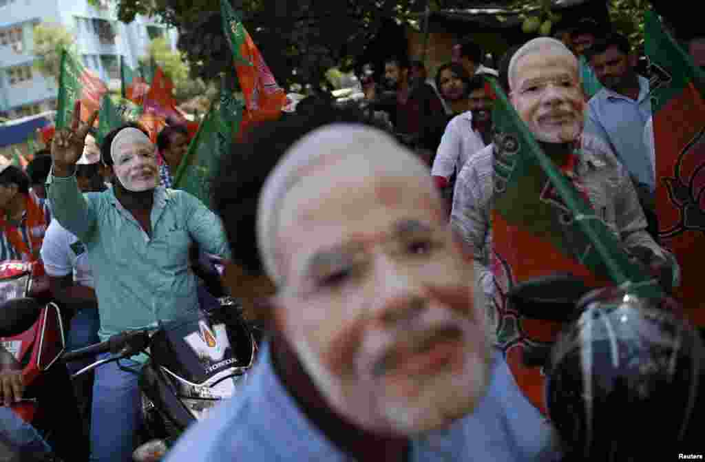 Supporters of Bharatiya Janata Party (BJP) wearing masks of Indian Prime Minister-designate Narendra Modi participate in a celebration rally ahead of his swearing-in ceremony, Mumbai, May 26, 2014.