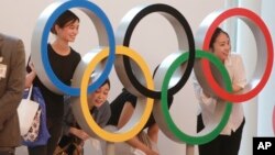 Para penumpang berpose dengan logo Cincin Olimpiade di bandara internasional Haneda di Tokyo, Jepang (foto: ilustrasi). 
