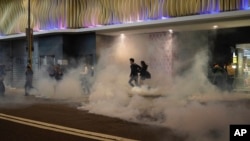 Los manifestantes dentro de los centros comerciales arrojaron paraguas y otros objetos a la policía, que a su vez lanzó gases lacrimógenos el martes 24 de diciembre de 2019 en Hong Kong.