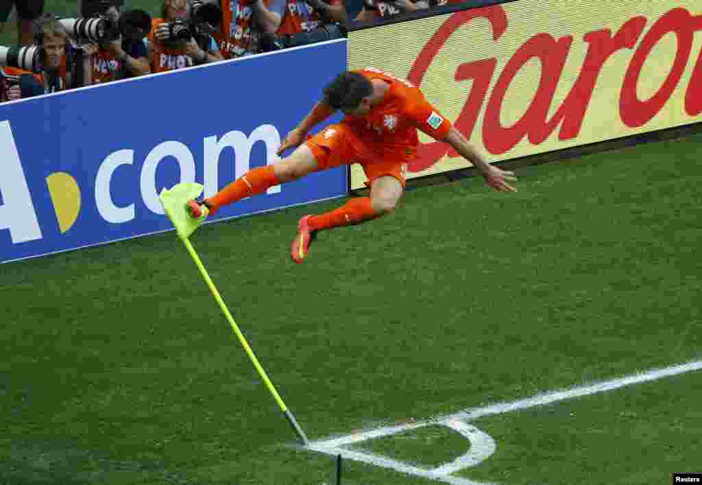 Klaas-Jan Huntelaar of the Netherlands kicks a corner flag to celebrate his goal against Mexico at the Castelao arena in Fortaleza, June 29, 2014.