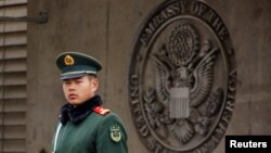 FILE - Paramilitary police officer guards the entrance to the U.S. embassy in Beijing, China, April 5, 2018. 