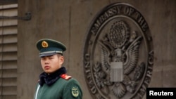 FILE - Paramilitary police officer guards the entrance to the U.S. embassy in Beijing, China, April 5, 2018. 