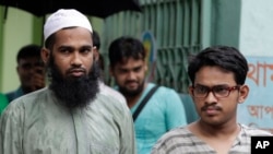 Suspected Muslim militants Saad-al-Nahin, right, and Masud Rana, who were arrested in the last week's killing of a secular blogger, stand before the media in Dhaka, Bangladesh, Friday, Aug. 14, 2015.