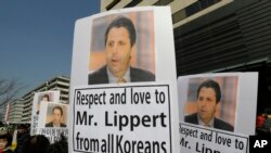 South Korean conservative activists hold portraits of U.S. Ambassador to South Korea Mark Lippert during a rally demanding his quick recovery near the U.S. embassy in Seoul, South Korea, March 6, 2015.