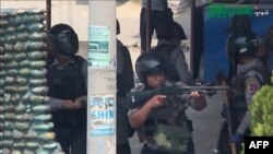 Dalam foto dari tangkapan layar AFPTV dan siaran Myitkyina News Journal tampak polisi membidik senjatanya saat menindak demonstrasi antikudeta di Myitkyina di negara bagian Kachin, Myanmar, Sabtu, 27 Maret 2021. (Foto: AFP dan sumber lain)