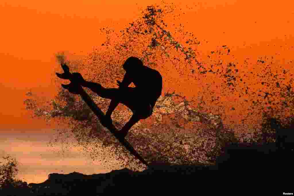 A surfer surfs after sunset in Cardiff, California, Jan. 7, 2020.