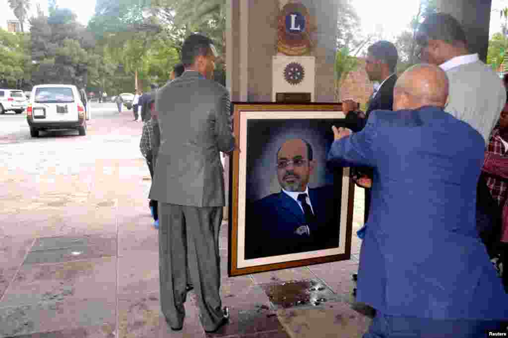 Officials move a portrait of Meles shortly after the announcement of his death in Addis Ababa August 21, 2012. 