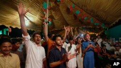 Supporters of Pakistani politician Imran Khan, chief of Pakistan Tehreek-e-Insaf party, celebrate projected unofficial results announced by television channels indicating their candidates' success in the parliamentary elections in Islamabad, Pakistan, Wednesday, Thursday, July 26, 2018.